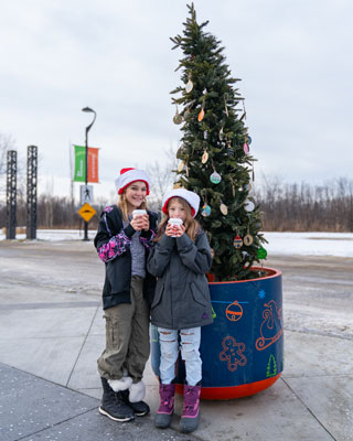 Two girls standing in front of Kindness Tree