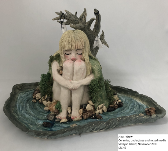 Ceramic artwork of girl with knees held to face sitting under a tree