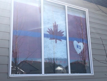 Window painted with the Canada flag and a white heart with the letters NS in red in the centre